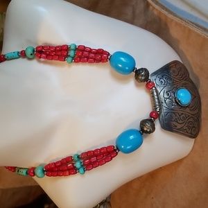 Silver necklace with turquoise and coral colored beads.